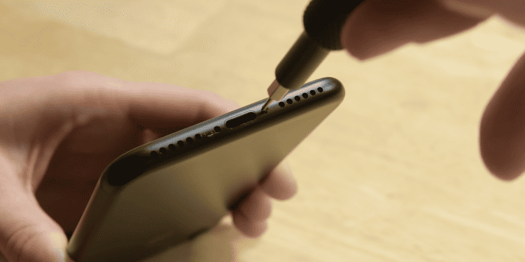 Unscrew pins next to the charging port