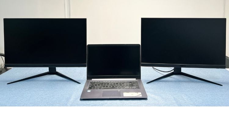 laptop in middle two screens at the side