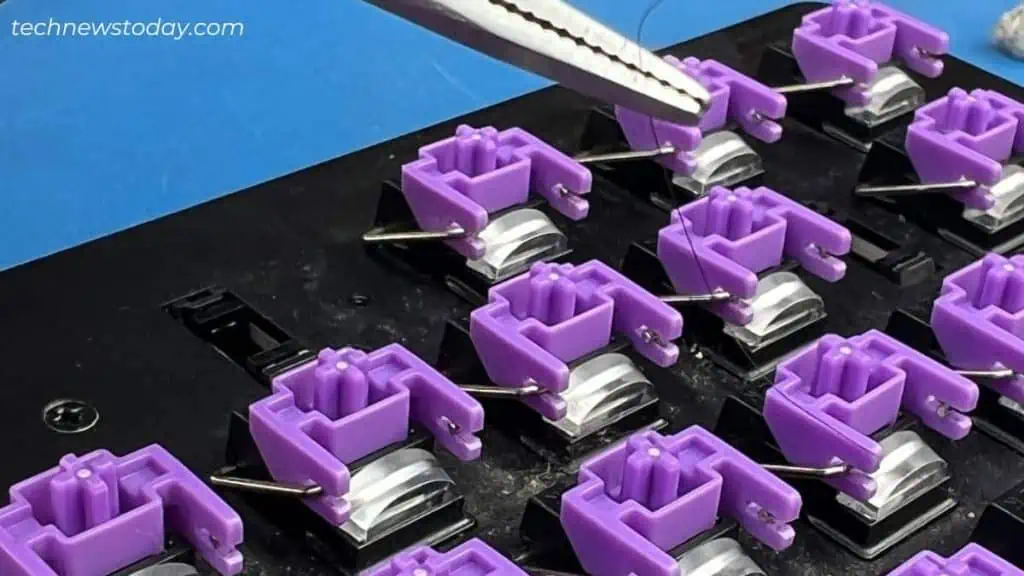 pulling-hair-strand-using-tweezers-from-razer-keyboard-1024x576